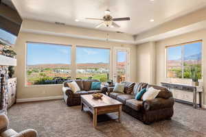 Carpeted living room featuring a wealth of natural light, a mountain view, and ceiling fan