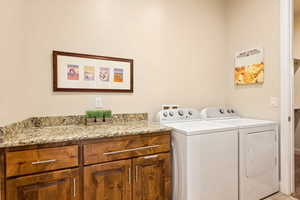 Clothes washing area featuring cabinets and washing machine and clothes dryer