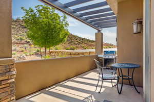 Balcony featuring area for grilling and a pergola