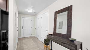 Doorway to outside featuring electric panel and light wood-type flooring