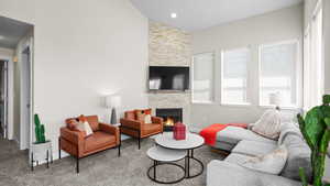 Carpeted living room with vaulted ceiling and a fireplace