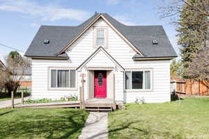 Bungalow-style house featuring a front yard and a wooden deck