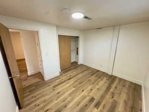 Unfurnished bedroom featuring a closet and hardwood / wood-style floors