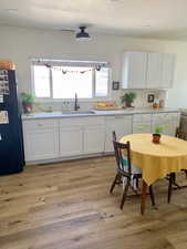 Kitchen with white cabinetry, white dishwasher, and black fridge