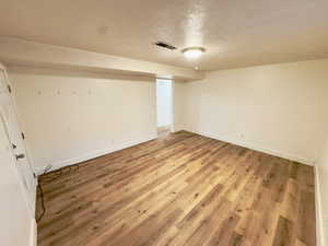 Basement featuring hardwood / wood-style floors and a textured ceiling