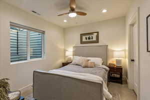 Carpeted bedroom featuring ceiling fan