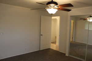 Unfurnished bedroom featuring crown molding, carpet floors, a closet, and ceiling fan