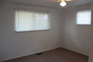 Empty room featuring ornamental molding, carpet floors, and ceiling fan