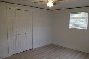 Unfurnished bedroom featuring a closet, ceiling fan, and light hardwood / wood-style flooring