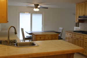 Kitchen featuring a center island, stainless steel gas cooktop, and tile counters