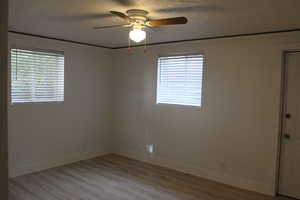 Unfurnished room with light hardwood / wood-style floors, a textured ceiling, and ceiling fan