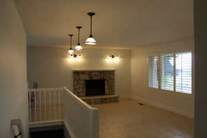 Unfurnished living room featuring a stone fireplace