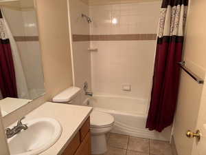 Full bathroom with tile patterned floors, shower / bath combo, toilet, and sink