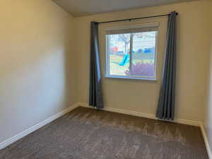 Unfurnished room featuring dark carpet