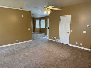 Empty room featuring ceiling fan and carpet floors