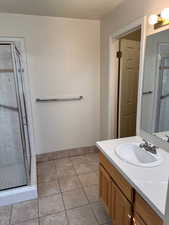 Bathroom featuring vanity, tile patterned floors, and a shower with door