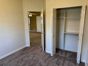 Unfurnished bedroom with dark colored carpet and a closet