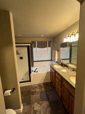 Primary bathroom with vanity, plus walk in shower, and tile patterned flooring