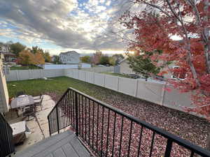 Deck at dusk with a yard and a patio area