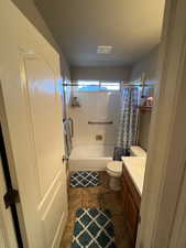 Full bathroom with vanity, shower / bath combo with shower curtain, toilet, and tile patterned floors