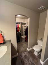 Bathroom with vanity, toilet, and tile patterned flooring