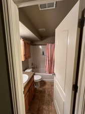 Full bathroom featuring vanity, shower / bath combo, toilet, and tile patterned flooring