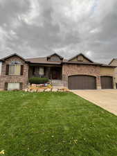 View of front facade with a front lawn and a garage