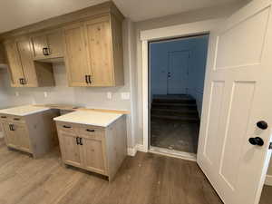 Kitchen with light brown cabinetry and light hardwood / wood-style flooring