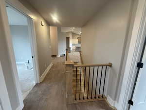 Corridor featuring vaulted ceiling and dark hardwood / wood-style floors