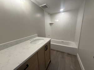 Bathroom featuring hardwood / wood-style floors, vanity, and a textured ceiling