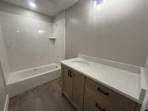 Bathroom with shower / bath combination, vanity, and hardwood / wood-style flooring