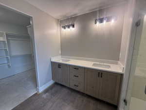 Bathroom with a textured ceiling, vanity, and hardwood / wood-style flooring