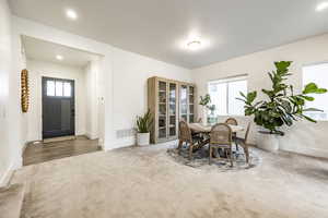 Carpeted dining area with plenty of natural light