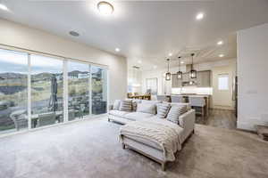 Living room with sink, a mountain view, hardwood / wood-style flooring, and a healthy amount of sunlight