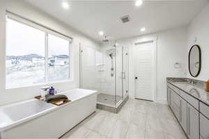 Bathroom featuring vanity and shower with separate bathtub