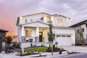 View of front of property featuring a garage and a porch