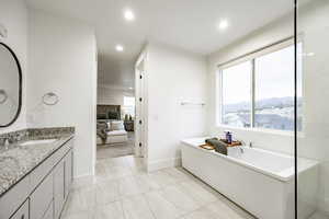 Bathroom with vanity, a mountain view, a washtub, and tile patterned flooring