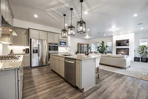 Kitchen with sink, appliances with stainless steel finishes, hanging light fixtures, and gray cabinetry