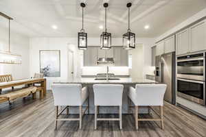 Kitchen featuring hardwood / wood-style floors, stainless steel appliances, and pendant lighting