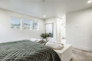 Bedroom with light carpet and ensuite bath