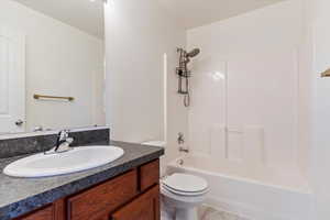 Full bathroom with vanity, toilet, and  shower combination