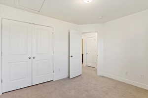 Unfurnished bedroom with a closet and light colored carpet