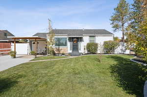 View of front facade featuring a carport and a front lawn