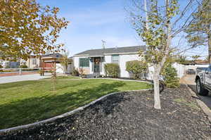 Ranch-style home featuring a front lawn