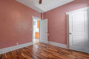 Unfurnished bedroom featuring dark hardwood / wood-style flooring and ceiling fan