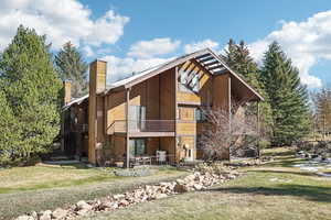 Exterior space featuring central AC, a front yard, and a balcony