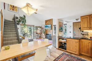 Interior space featuring vaulted ceiling, light hardwood / wood-style flooring, and backsplash