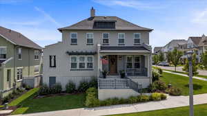 View of front property with a front lawn and covered porch