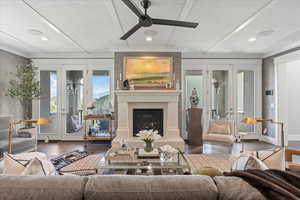 Living room featuring dark hardwood / wood-style flooring, french doors, ceiling fan, and a fireplace