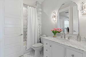 Full bathroom featuring vanity, tile patterned floors, toilet, and shower / bathtub combination with curtain